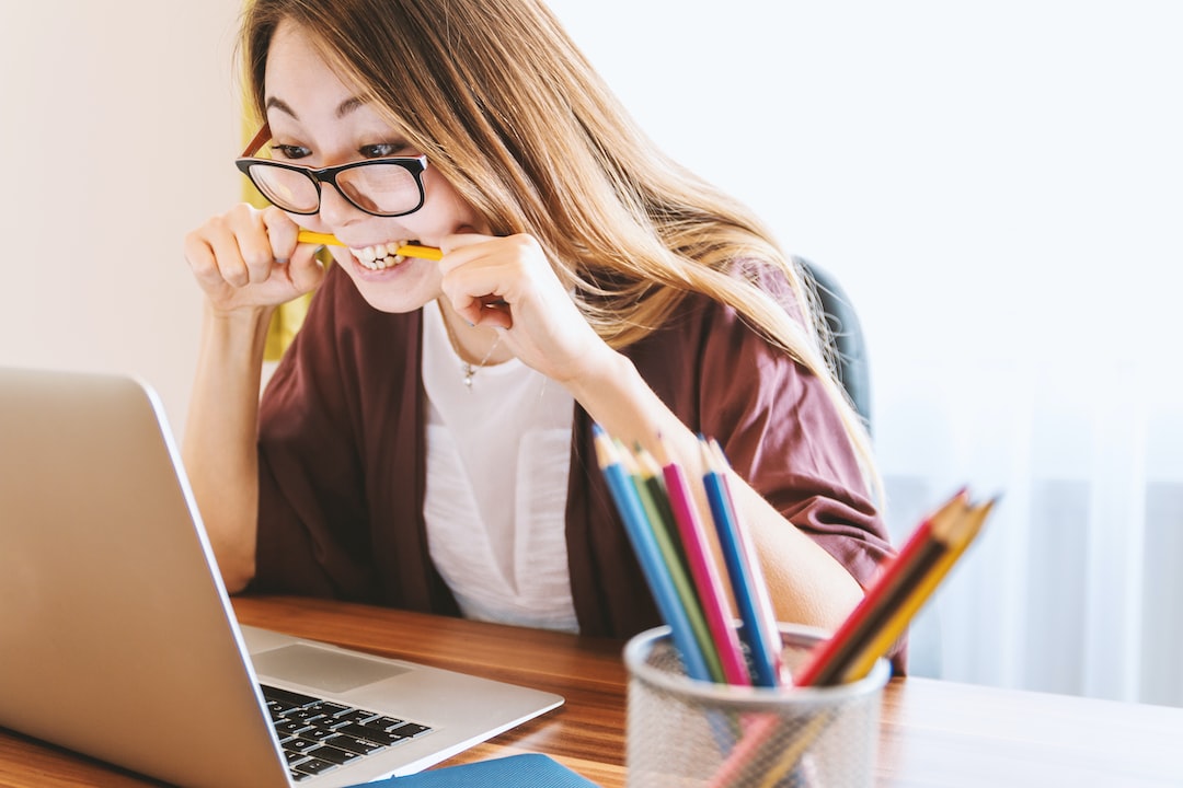 Pencil Biting over informational interviews Anxious lady biting a pencil at her laptop at the thought of informational interviews