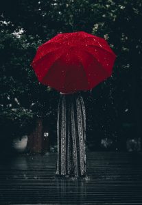 Woman holding an umbrella, representing how buffering can protect us from the stress of motherhood